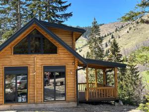 a log cabin with large windows and a porch at Mirsads Mountain Cottage in Plav