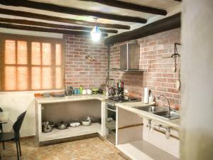 a kitchen with a sink and a brick wall at Guacuco Living in El Hato