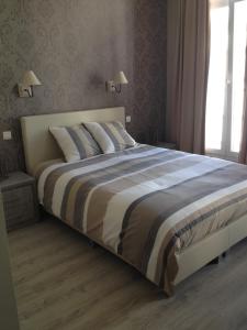 a bedroom with a large bed with a striped blanket at Hotel Chaplin in Blankenberge