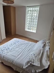 ein ungemachtes Bett in einem Zimmer mit Fenster in der Unterkunft Cozy apt Paris centre, 5 mins Louvre in Paris