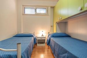 una camera da letto con due letti e una finestra di Scalingi Family Apartments a Sperlonga