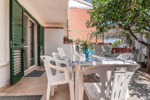 un tavolo bianco e sedie su un patio di Scalingi Family Apartments a Sperlonga