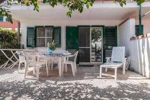 un tavolo e delle sedie seduti su un patio di Scalingi Family Apartments a Sperlonga