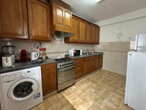 a kitchen with a washing machine and a refrigerator at Casa do Mar in Salema