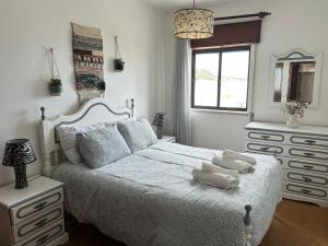 a bedroom with a bed with two towels on it at Casa do Mar in Salema