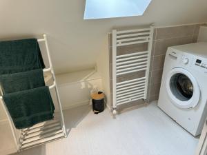 a laundry room with a washing machine and a towel rack at Gite des 3 sœurs in Vernon