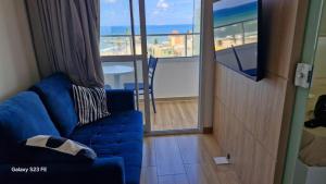 a living room with a blue couch and a balcony at Apt lindo e novo vista mar com garagem orla de Pituba in Salvador