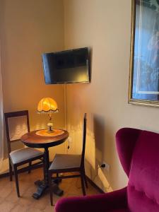 a room with a table with a lamp and a chair at Le vecchie poste di Benedetta in Castiglione del Lago +13 photos