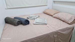a bed with two pillows and towels on it at Apt lindo e novo vista mar com garagem orla de Pituba in Salvador