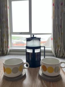 two cups sitting on a table next to a juicer at Pegasus Place in Lerwick