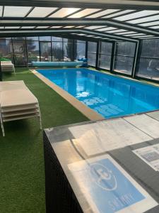 a large swimming pool in a building with a table at Évasion du préhaut in Tournehem +14 photos