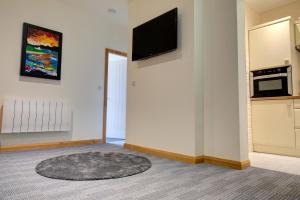 Una sala de estar con un televisor de pantalla plana en una pared. en King street, en Bacup