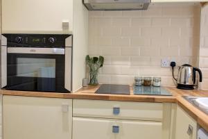 una cocina con estufa horno superior al lado de un fregadero en King street, en Bacup