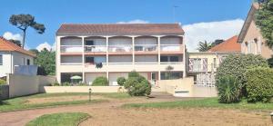 a large house with a balcony in a yard at Plage et centre à 100m avec balcon et parking privé 4 pers in Saint-Brévin-lʼOcéan +3 photos