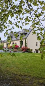 a large white house with a yard with green grass at Campagne à la Ville in Pontivy