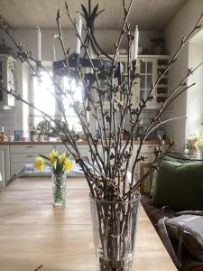 a vase with branches in it on a table at Erikslund in Hurva