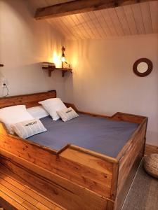 a bedroom with a wooden bed with two pillows at Oudoty in Kerlouan