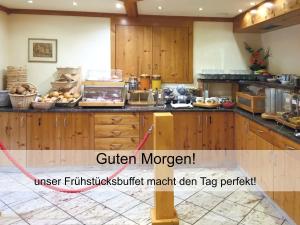 a kitchen with wooden cabinets and a counter top at GarniHotel zur Linde - Bayerischer Wald - aktivCard mit 154 kostenfreien Leistungen - kostenloser Parkplatz in Lohberg