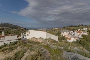 ein Dorf auf einem Hügel mit weißen Gebäuden in der Unterkunft RentitSpain El Castillete Encanto con vistas al mar in La Garnatilla
