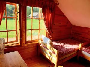 a bedroom with a bed in a room with windows at Vakarvēji in Mujani