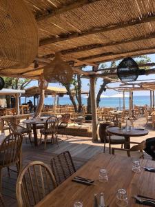 a restaurant with tables and chairs and a view of the ocean at Villa ALOHA pool-beach 500m in Santa-Maria-Poggio