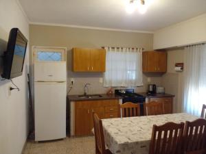 a kitchen with a table and a white refrigerator at LOS CACTUS in Tandil