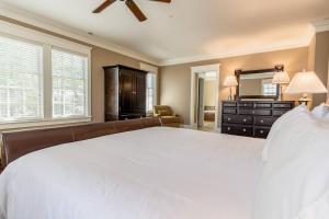 a bedroom with a large white bed and a dresser at 1 Mile to Omni Homestead w/ 5 suites + Gameroom in Hot Springs +57 photos
