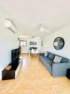 a living room with a blue couch and a tv at Apartamento en primera línea de mar in Hospitalet de l'Infant