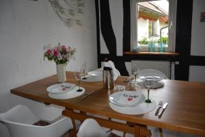 een houten tafel met witte borden en wijnglazen bij Ferienhaus 1534 in Neustadt an der Weinstraße