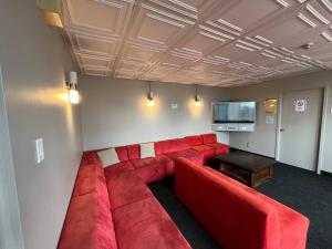 a living room with a red couch and a flat screen tv at Neill Wycik Hostel in Toronto