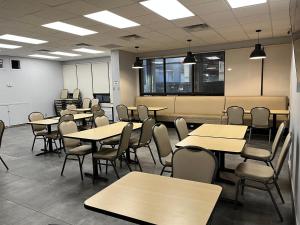 an empty classroom with tables and chairs at Neill Wycik Hostel in Toronto