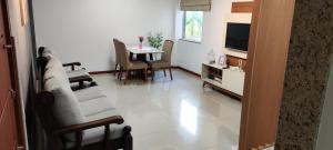 a living room with a couch and a tv and a table at Pedaço da quinta in Teresópolis
