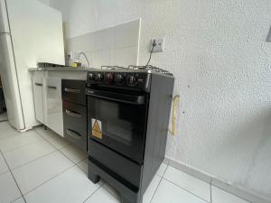 a kitchen with a black stove and a counter at Apartamento ao lado do Thermas e Animália Park in Cotia
