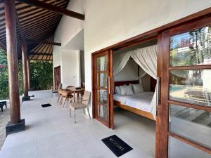 a bedroom with a bed and a table and chairs at Villa Light - Amed Bali in Amed
