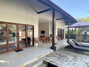 a house with a patio with a couch and an umbrella at Villa Light - Amed Bali in Amed +171 photos