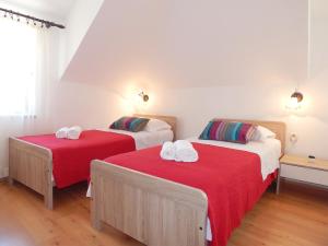 2 camas en una habitación con sábanas rojas y toallas blancas en City Center Apartments, en Split