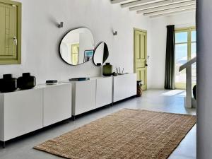 a white bathroom with a large mirror and a rug at VILLA AGNES MYKONOS in Mýkonos City +92 photos
