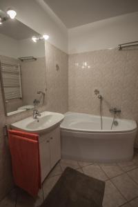 een badkamer met een wit bad en een wastafel bij Velvet Łucka in Warschau