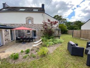 eine Terrasse mit Tisch und Stühlen in einem Hof in der Unterkunft Villa La Glycine in Saint-Avé