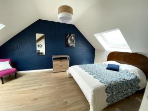ein Schlafzimmer mit einem Bett und einer blauen Wand in der Unterkunft Villa La Glycine in Saint-Avé