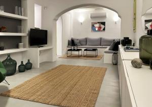 a living room with a couch and a tv at VILLA AGNES MYKONOS in Mýkonos City