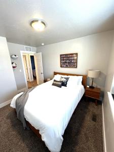 a bedroom with a large white bed and a lamp at Hole in One Place with Hot Tub and Ping Pong in Boise