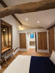 a bedroom with a bed and a chair in a room at The Heritage Hideaway in Charlwood