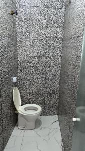 a bathroom with a toilet and a glass shower at Hotel rebeka in São Paulo