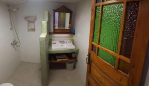 a bathroom with a sink and a mirror and a door at Corones House in Frilingiánika