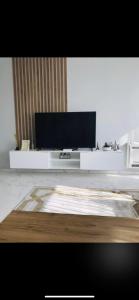 ein Wohnzimmer mit einem Flachbildfernseher auf einem Tisch in der Unterkunft Cheerful 3 bedroom villa with free parking seeview in Hamallë