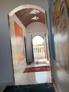 a hallway with paintings on the walls of a house at Maleka nubian guest house in Aswan