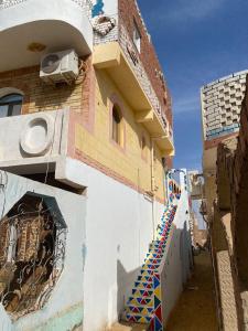 a building with a staircase on the side of it at Maleka nubian guest house in Aswan