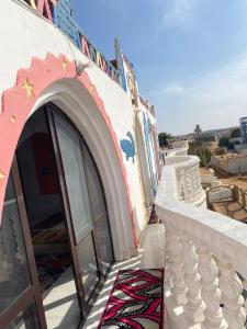 a building with a door and a rug on a balcony at Maleka nubian guest house in Aswan +8 photos