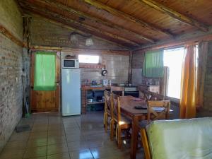 a kitchen with a table and a refrigerator at CABAÑAS TREVELIn in Trevelín
